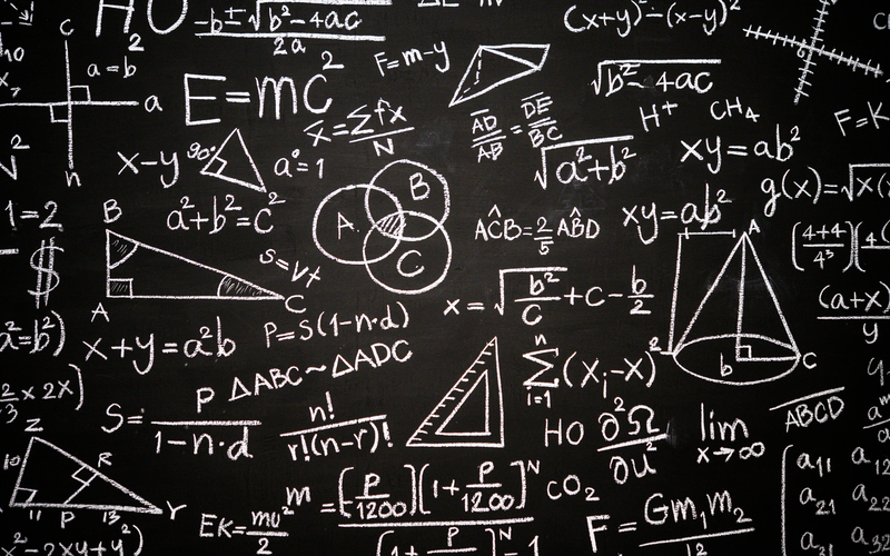 Blackboard inscribed with scientific formulas and calculations in physics, mathematics and electrical circuits. Science and education background.